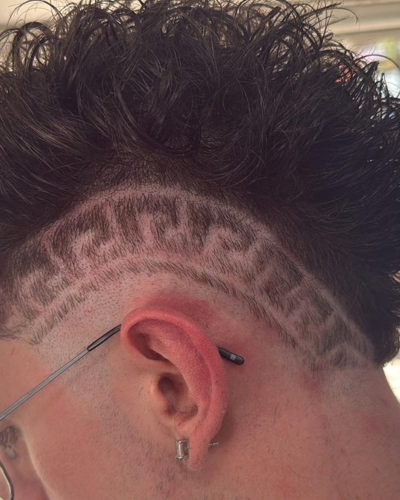 Grecas rapadas bajo el pelo rizado.