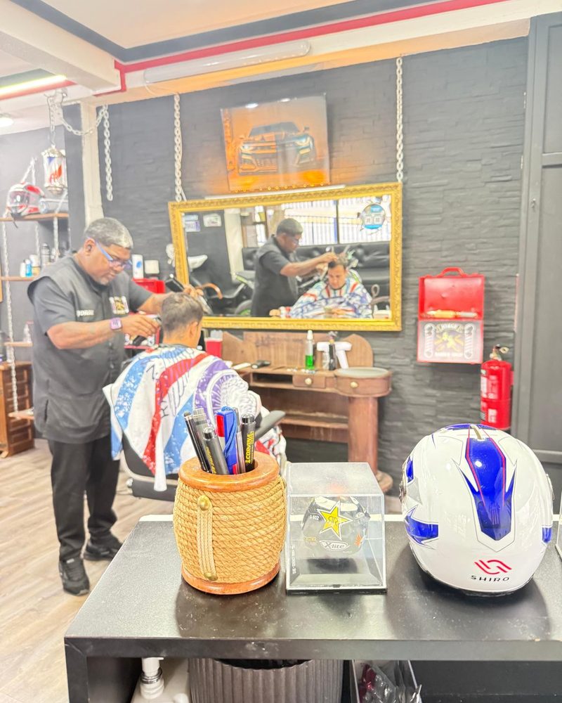El local trabajando, con el casco de moto en primer plano.