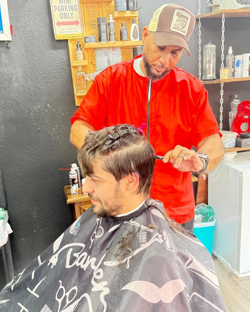 Alexander cortándole el pelo a un cliente.