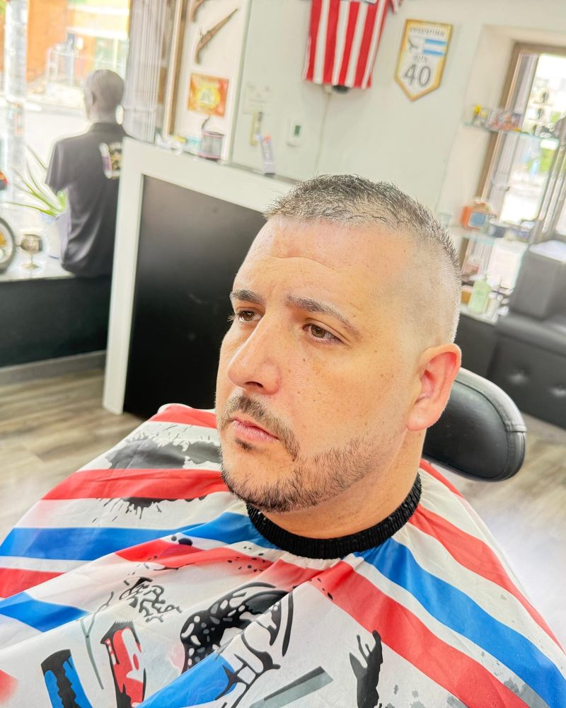 Degradado corto con la barba recortada, de perfil.