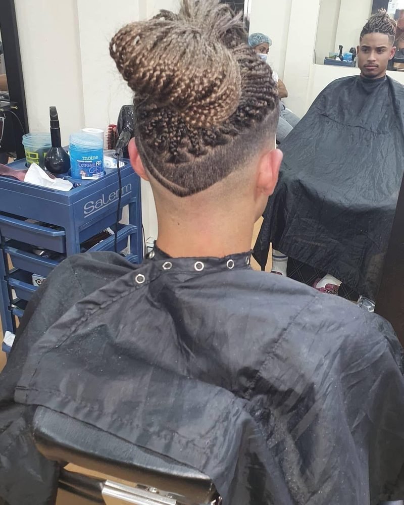 Trenzas recogidas en un moño y la nuca rapada.