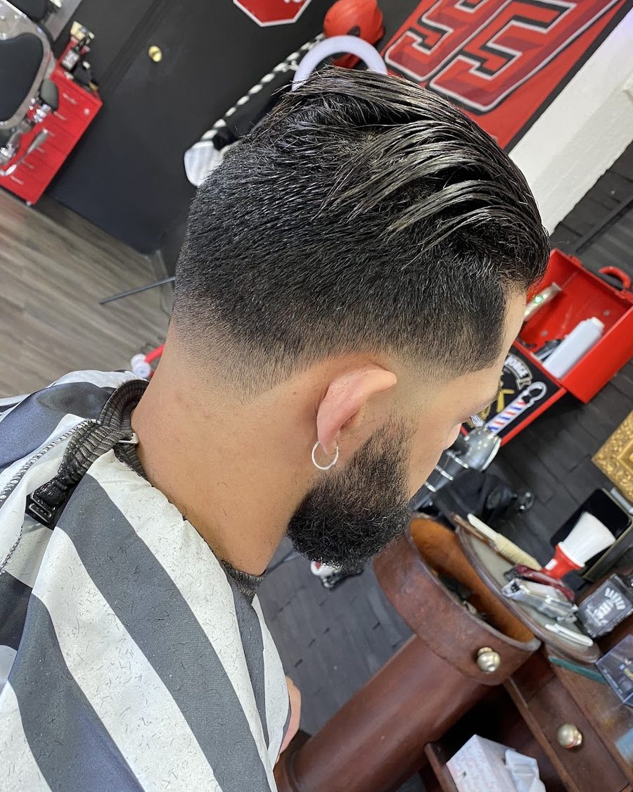 Corte terminado visto desde atrás: degradado en la nuca y la barba perfilada.